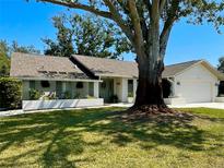 Charming single-story home featuring a well-manicured lawn and mature landscaping including a large tree at 3202 Meadow Run Dr, Venice, FL 34293