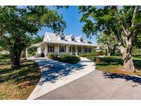 White farmhouse with metal roof, spacious porch, and landscaped yard at 3800 Acline Rd, Punta Gorda, FL 33950