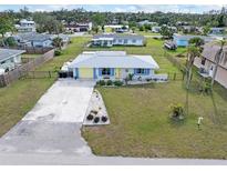 Cute yellow and blue house with nicely landscaped front yard at 817 E 6Th St, Englewood, FL 34223