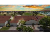 Inviting townhome featuring a red tile roof, attached garage, palm trees, and well-maintained landscaping at 1640 Atares Dr # 6, Punta Gorda, FL 33950