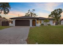 Well-maintained single-story home with attached garage, green grass, and inviting entrance at sunset at 340 Carmel Rd, Venice, FL 34293