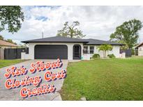 Charming single-story home with a well-manicured lawn, black garage door, and inviting front entrance at 340 Carmel Rd, Venice, FL 34293