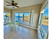 Bright breakfast nook offers stunning waterfront views from large windows, creating a serene dining experience at 1 Colony Point Dr # 3C, Punta Gorda, FL 33950