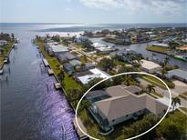 Waterfront home features a private dock, screened-in lanai, and well-maintained landscaping at 193 Beeney Se Rd, Port Charlotte, FL 33952