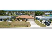 Well-maintained waterfront home featuring a spacious driveway and mature landscaping at 164 Chelsea Nw Ct, Port Charlotte, FL 33952