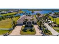 Beautiful home featuring lush landscaping, a brick driveway, and a tile roof, near the waterfront at 17557 Ohara Dr, Port Charlotte, FL 33948