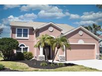 Charming two-story home featuring a well-manicured lawn and a two-car garage at 5275 Layton Dr, Venice, FL 34293