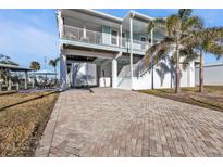 Inviting two-story waterfront home with a brick driveway and covered parking at 4297 Nettle Rd, Port Charlotte, FL 33953
