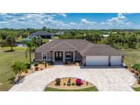 Charming home boasts a three-car garage, well-manicured lawn and tasteful landscaping at 4122 Library St, Port Charlotte, FL 33948