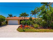 Charming home with well-manicured landscaping, a red tile roof, and a brick paver driveway at 805 Brenda Ct, Punta Gorda, FL 33950