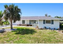 Well-kept single-story home featuring a tidy lawn, established landscaping, and an attached garage at 148 Salem Nw Ave, Port Charlotte, FL 33952