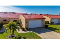 Charming villa with a vibrant red roof, well-manicured lawn, and attached garage at 1780 Deborah Dr # 15, Punta Gorda, FL 33950