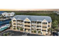 Three-story condominium building with a metal roof, multiple balconies, and a convenient parking area at 1960 Oregon Trl # 2B, Englewood, FL 34224