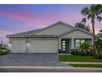 Charming single-Gathering home with a well-manicured lawn, a three-car garage, and beautiful landscaping at 12717 Morning Mist Pl, Venice, FL 34293