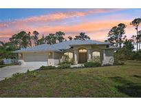 Charming single-story home featuring a well-manicured front yard, attached garage, and neutral color palette at 3896 Slayton Ave, North Port, FL 34286