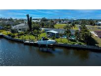 Inviting waterfront home featuring a private dock, boat lift and a screened-in pool for idyllic waterfront living at 125 Ott Cir, Port Charlotte, FL 33952