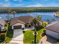 Stunning waterfront home boasts lush landscaping, a well-manicured lawn, and a private boat dock at 1339 Casey Key Dr, Punta Gorda, FL 33950