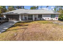 Charming single-story home with an attached two-car garage, beautiful landscaping, and ample curb appeal at 2325 Hanford Ln, North Port, FL 34288