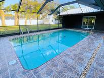 Inviting screened-in pool with tile surround and outdoor area, perfect for relaxation and entertainment at 4128 Durant St, Port Charlotte, FL 33948