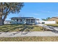 Charming single-story home with a well-maintained lawn and cozy front porch at 5909 Talbrook Rd, North Port, FL 34287