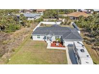 Well maintained home with a front lawn, driveway, and a large area to park an RV or boat at 11338 Willmington Blvd, Port Charlotte, FL 33981