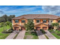 Beautiful townhome exterior showcasing a tile roof, brick driveway, and a two car garage at 20272 Lagente, Venice, FL 34293