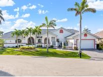 Beautiful single-story home with a tile roof, brick driveway, palm trees, and well-manicured lawn at 1105 Rum Cay Ct, Punta Gorda, FL 33950
