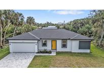 Charming single-story home featuring a striking yellow door, manicured lawn, and spacious driveway at 1117 Vernon Ave, Port Charlotte, FL 33948