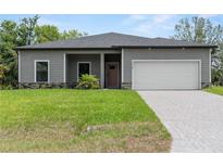 Charming single-story home featuring a two-car garage, well-maintained lawn, and welcoming front entrance at 1790 New London St, North Port, FL 34288