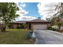 Charming single-story home featuring a two-car garage, well-maintained lawn, and mature landscaping at 2281 Tolbert St, Port Charlotte, FL 33948