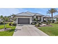 Charming single-story home with meticulously landscaped front yard and gray metal roof at 145 Leland Sw St, Port Charlotte, FL 33952