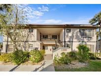 Inviting condo exterior with lush landscaping and covered walkways, offering a charming curb appeal at 19505 Quesada Ave # Ee204, Port Charlotte, FL 33948