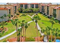 Aerial view of a community featuring palm trees, walking paths, and beautifully landscaped grounds at 3006 Caring Way # 431, Port Charlotte, FL 33952