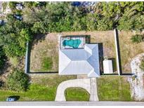 Aerial view of home showcasing a screened pool, fenced yard, shed, and curved driveway at 4520 Knollwood Dr, Punta Gorda, FL 33982