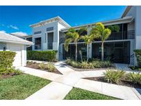 Beautifully landscaped condo building with palm trees, manicured shrubs, and inviting entrance walkways on a clear, sunny day at 14204 Heritage Landing Blvd # 724, Punta Gorda, FL 33955