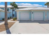 Inviting blue two-story home featuring dual garages and well-maintained landscaping at 5783 Sabal Trace Dr # 103B57, North Port, FL 34287