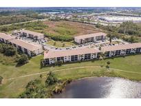 Expansive aerial shot of the condos showing green space, parking and lake views at 175 Kings Hwy # 538, Punta Gorda, FL 33983