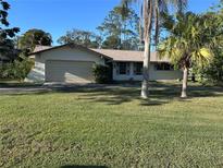 Charming single-story home features a well-maintained lawn and attached garage in a serene setting at 20262 Hamilton Ave, Port Charlotte, FL 33952