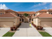 Mediterranean-style condo boasts a symmetrical facade, terracotta roof, manicured landscaping, and inviting driveway at 3959 San Rocco Dr # 612, Punta Gorda, FL 33950