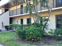 Two-story condo building with lush landscaping, covered balconies, and well-maintained grounds at 4000 Oakview Dr # L2, Punta Gorda, FL 33980