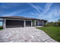 Beautiful single-story home featuring a large paver driveway and an attached three-car garage at 855 Rotonda Cir, Rotonda West, FL 33947