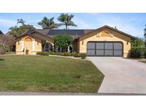 Inviting single-story home featuring a well-manicured lawn, mature trees, and a spacious driveway at 1225 Neapolitan Rd, Punta Gorda, FL 33983