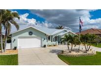 Single-Gathering home showcasing a well-manicured lawn, palm trees, and a spacious driveway at 1334 Via Milanese, Punta Gorda, FL 33950