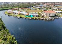 Aerial view of a waterfront condo with boat docks, beautiful landscaping, and lake view at 1344 Rock Dove Ct # D102, Punta Gorda, FL 33950