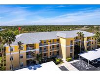 Bright condo building with yellow facade, multiple floors, and palm trees on a sunny day at 2081 Willow Hammock Cir # F101, Punta Gorda, FL 33983