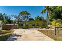 Charming single-story home with a long driveway and lovely yard featuring mature trees and green lawn at 8035 Hillman Ave, Punta Gorda, FL 33982