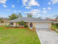Charming single-story home with a well-manicured lawn and mature landscaping at 916 S Gondola Dr, Venice, FL 34293