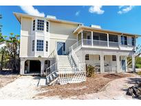 Inviting home featuring a charming two-story layout and a welcoming front entrance with ample natural light at 20 Palm Dr, Placida, FL 33946
