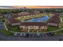 Scenic aerial view of a multi-Gathering home community with a serene pond and lush landscaping at 25100 Sandhill Blvd # R104, Punta Gorda, FL 33983