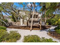 Beautiful exterior view with lush tropical landscaping and a classic multi-story home design at 5239 Siesta Cove Dr, Sarasota, FL 34242